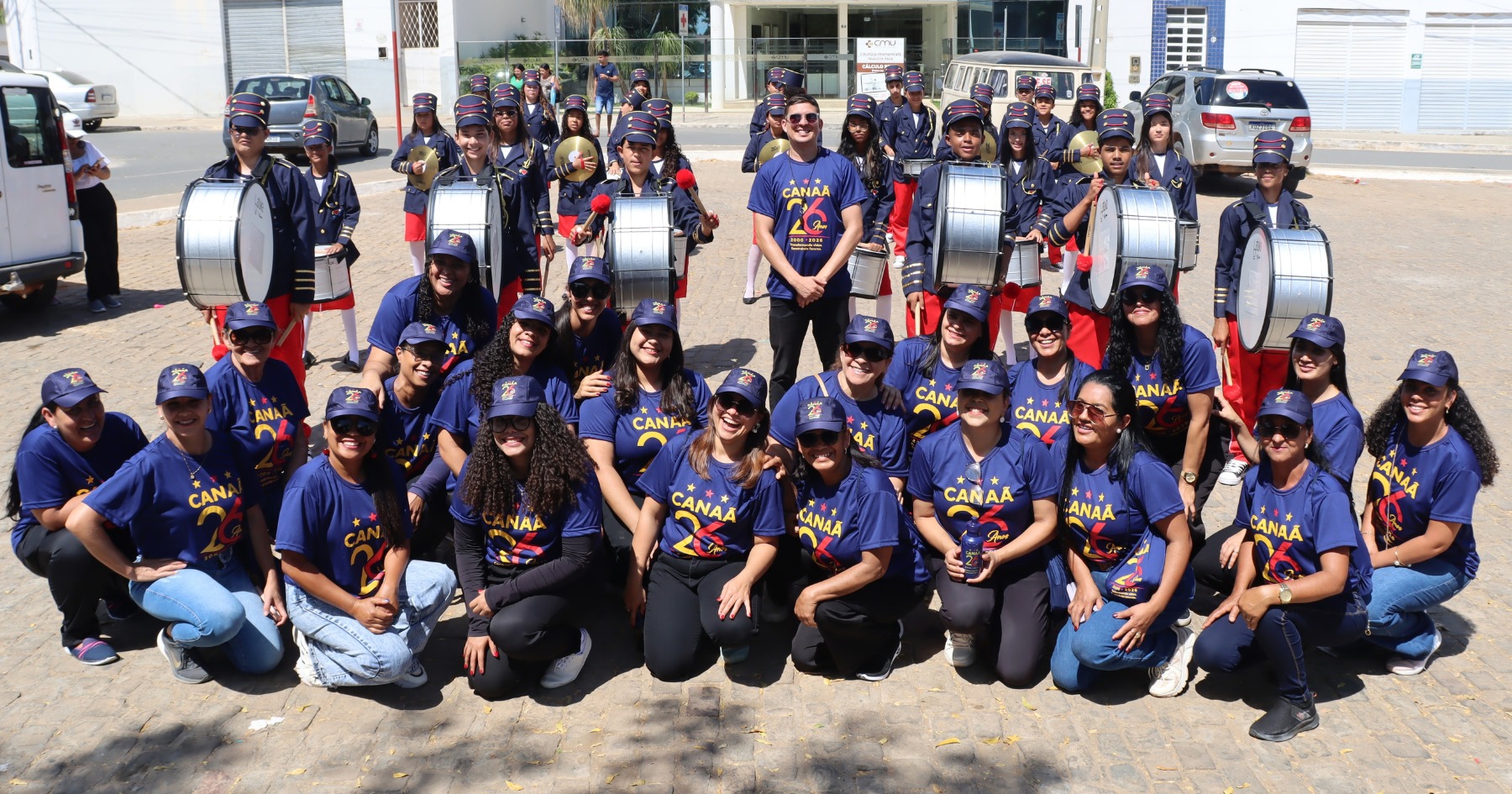 Colaboradores do Projeto Nova Canaã e integrantes da Banda Marcial posam juntos com os instrumentos em uma rua de Irecê.